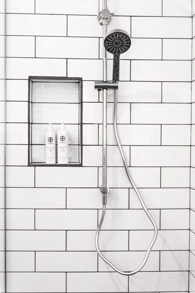 bathroom with shower and tile walls