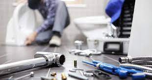 professionals working in a bathroom containing set of plumbing tools.png